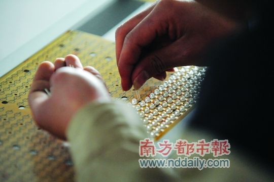 工人忙著安裝用于燈具發(fā)光的LED燈珠，這類工作處于LED燈具生產(chǎn)的最下游。資料圖